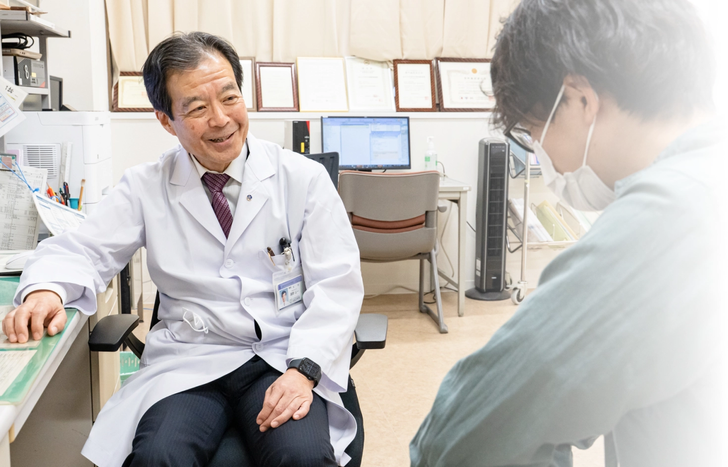 画像:診察を行う医師と患者の若い男性
